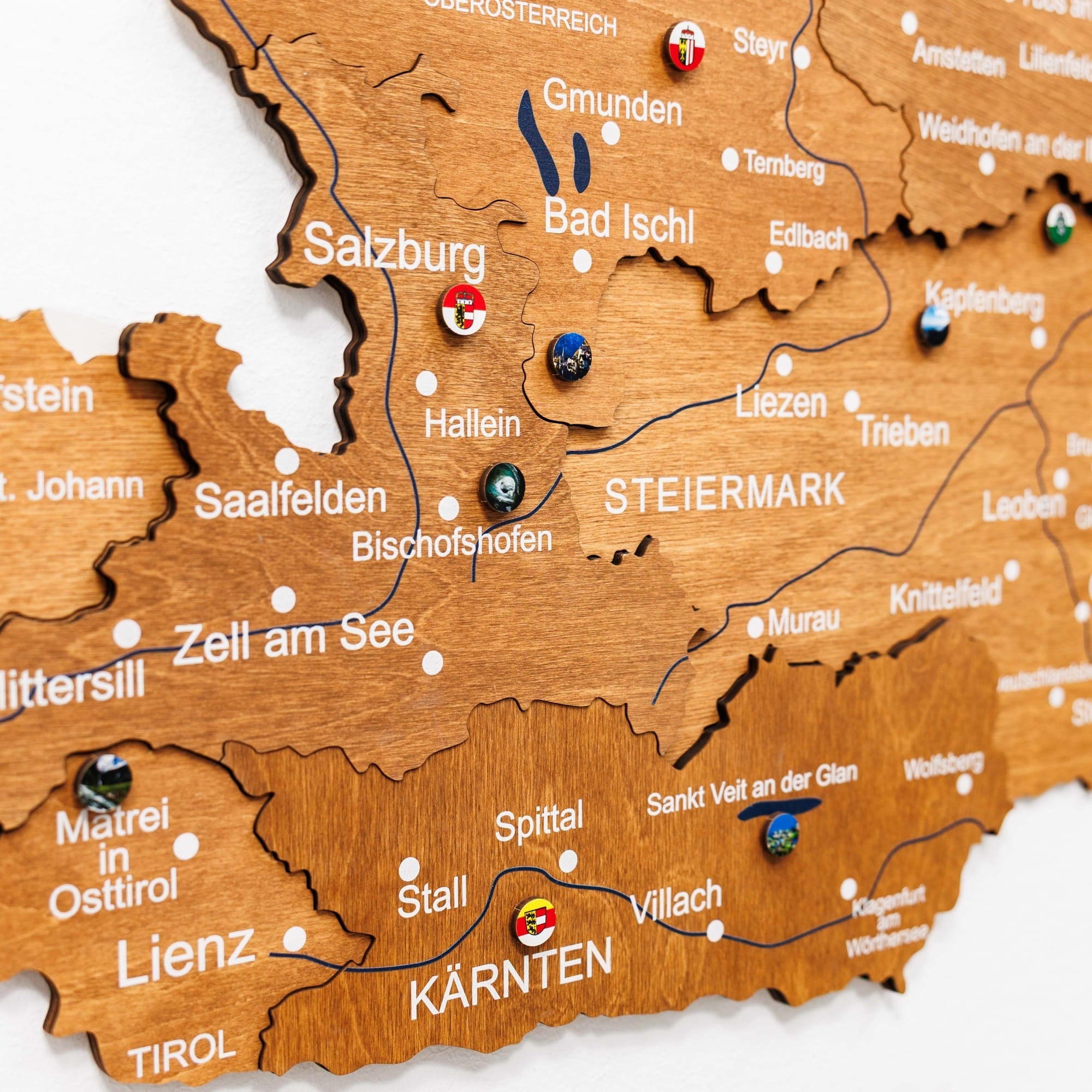 Wooden map of Austria with various locations marked by pins.