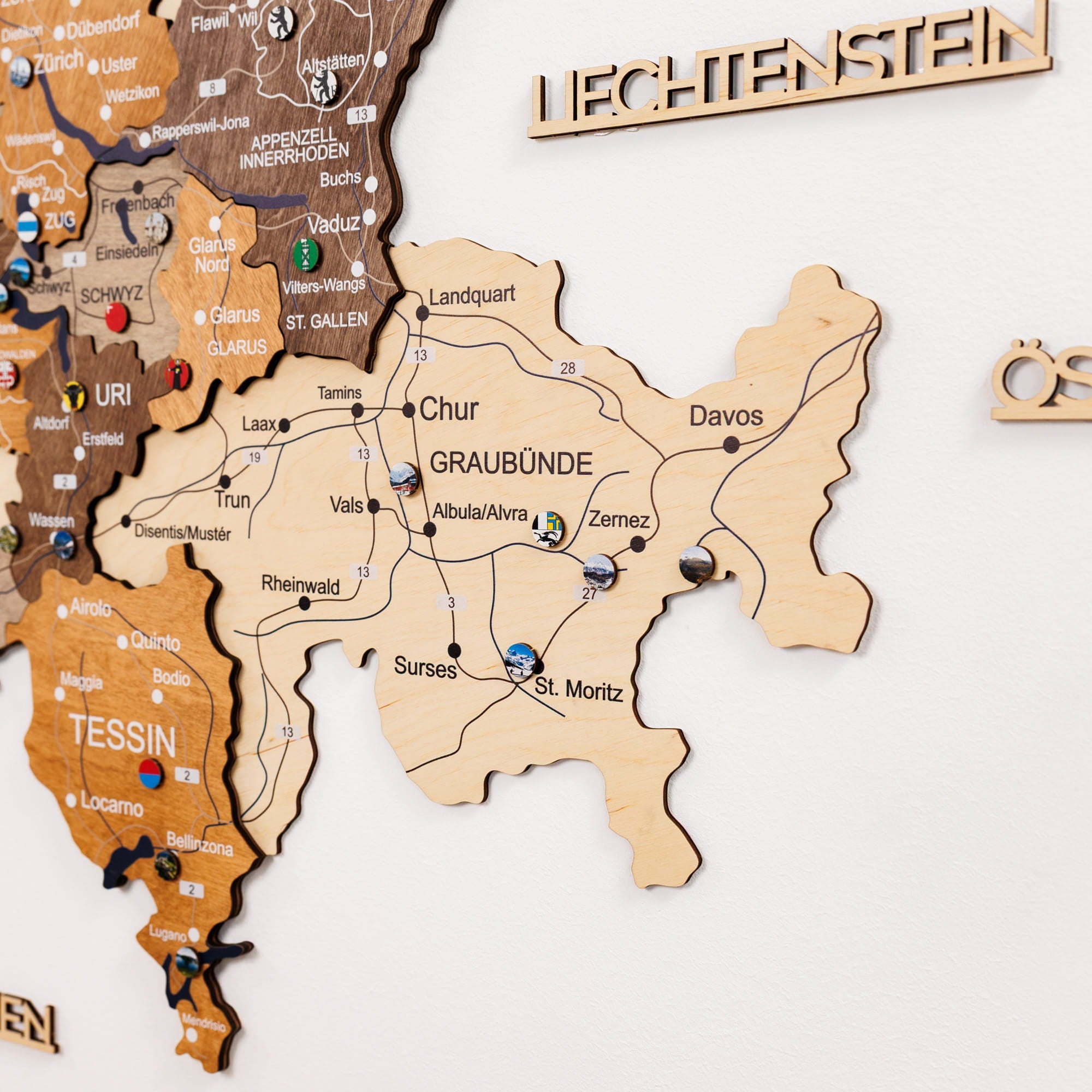 Wooden map of Switzerland with various regions labeled on a white background